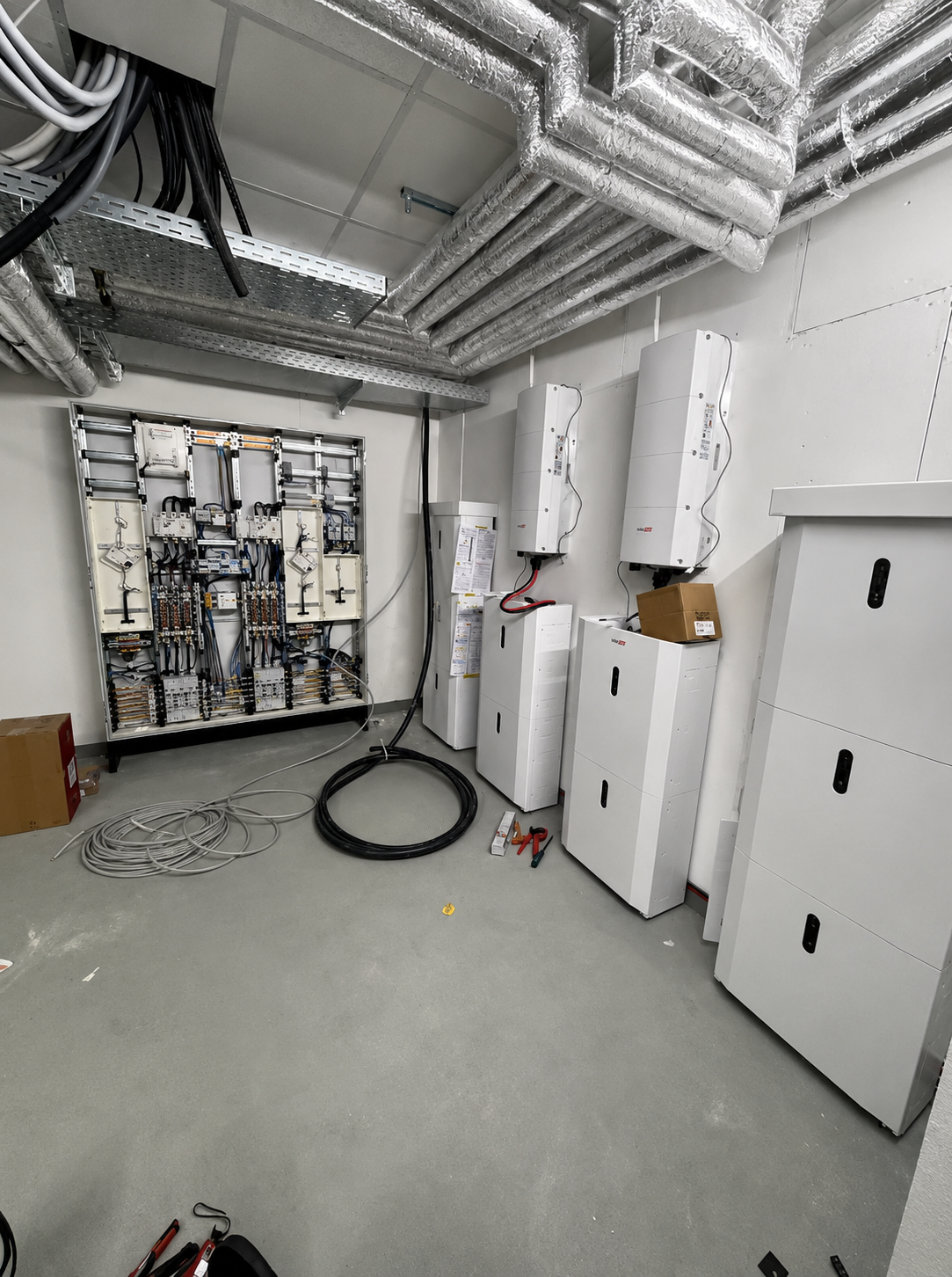 Technikraum mit gewerblichen Batteriespeichern, Wechselrichtern und Schaltschrank
