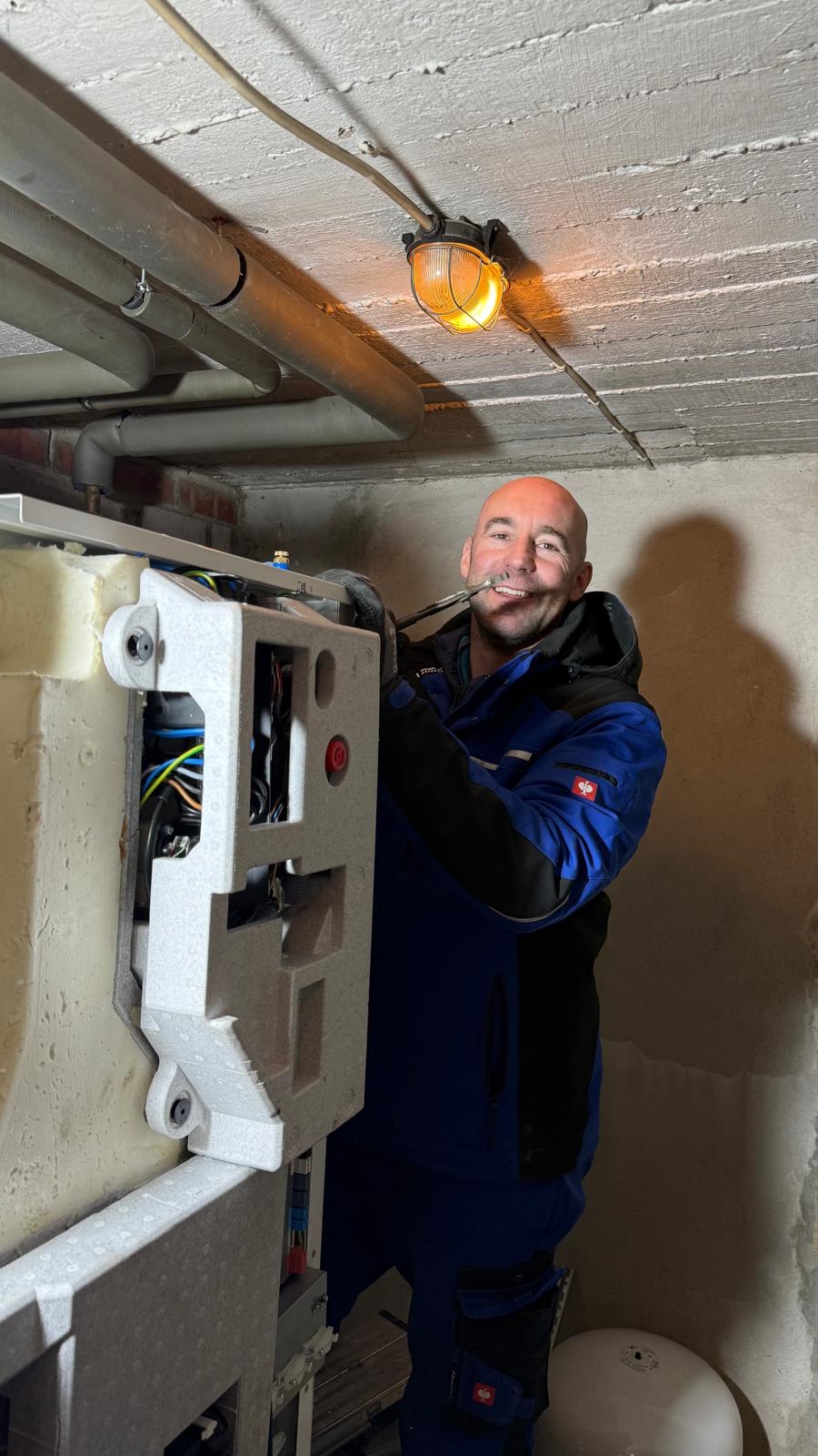 Techniker bei der Installation einer W&auml;rmepumpe im Keller